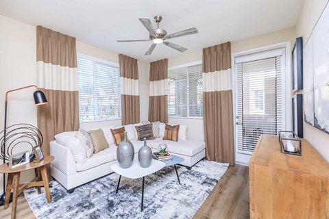 a living room with a white couch and a ceiling fan