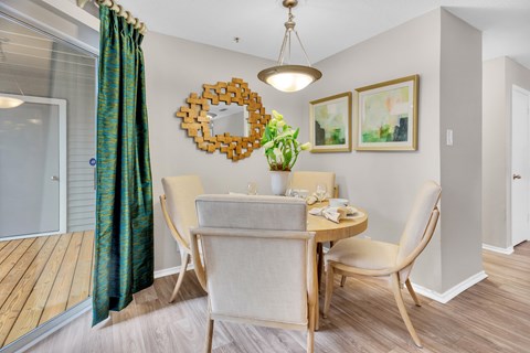 a dining room with a table and chairs and a mirror on the wall