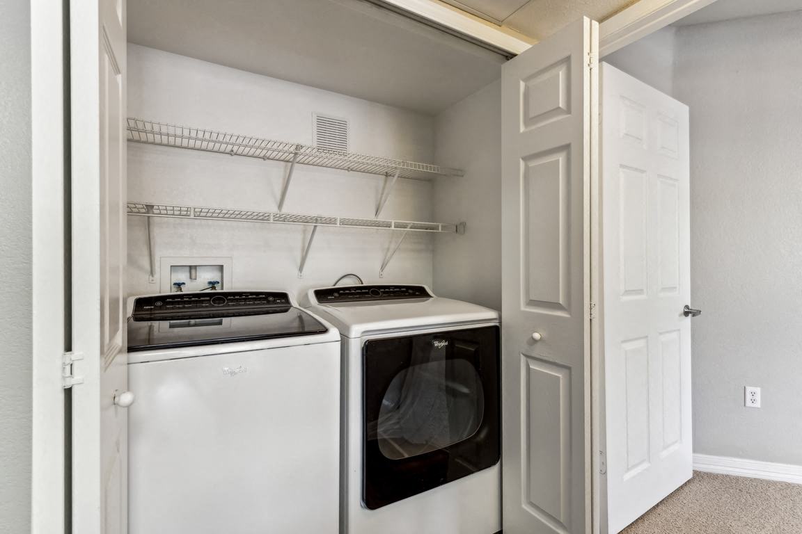 a white washer and dryer in a laundry room with a white door