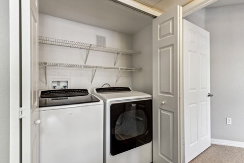 a white washer and dryer in a laundry room with a white door at Altezza High Desert, Albuquerque