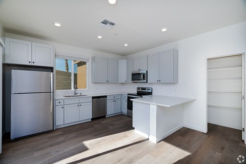 a renovated kitchen with white cabinets and stainless steel appliances