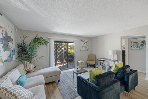 a living room with furniture and a sliding glass door to a patio