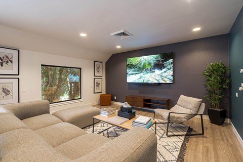 a living room with couches and a tv on the wall