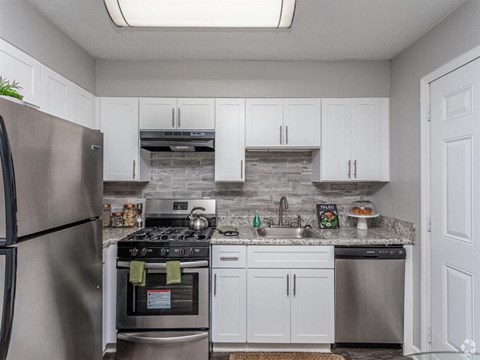 a kitchen with stainless steel appliances and white cabinets