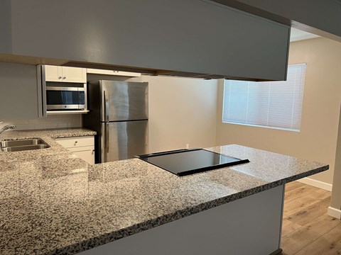 a kitchen with a granite counter top and a refrigerator