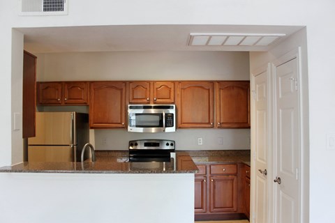 an empty kitchen with wooden cabinets and a counter top