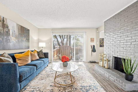 a living room with a blue couch and a fireplace