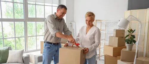 Couple tapping a box on moving day.