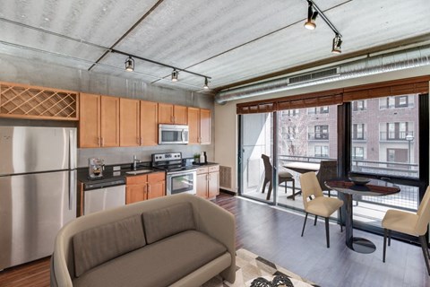 a living room with a couch and a kitchen and a sliding glass door