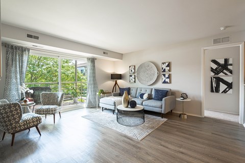 a living room with a couch and chairs and a door to a balcony