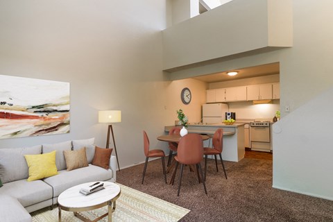 the living room and dining area of an apartment with a couch and a table