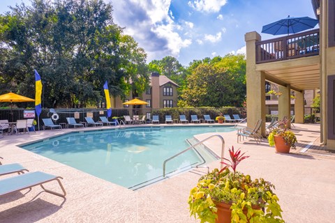 a swimming pool with lounge chairs and umbrellas at homewood suites by hilton