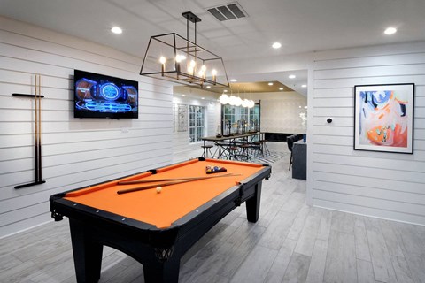 a pool table in a game room with a tv