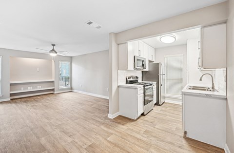 Open and airy kitchen and dining area in the D5 floor plan at Windridge On The Parkway Apartments in Dallas, TX